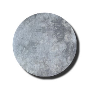 May include: A round, gray, fabric coaster with a mottled, marbled pattern.