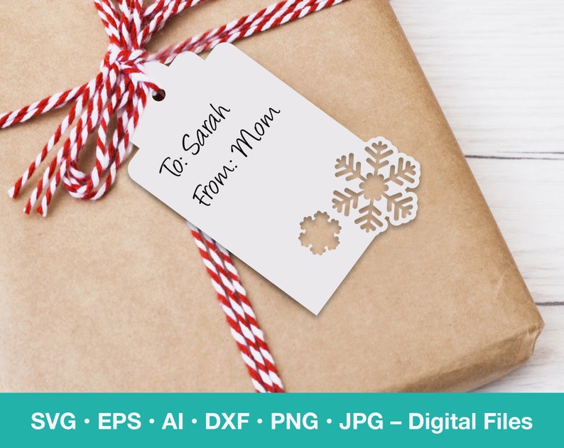 May include: A white gift tag with a snowflake design and the text "To: Sarah From: Mom". The tag is tied with a red and white striped ribbon to a brown gift box.