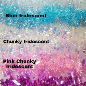 May include: Assortment of iridescent tinsel garland in various colors, including blue, white, pink, and purple. The garland is chunky and has a mirrored finish.