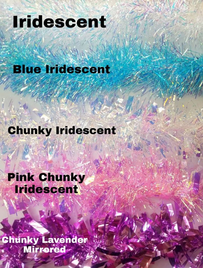 May include: Assortment of iridescent tinsel garland in various colors, including blue, white, pink, and purple. The garland is chunky and has a mirrored finish.