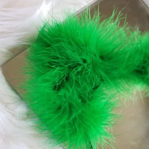 May include: A bright green feather boa. The boa is soft and fluffy, and it is perfect for adding a touch of fun to any outfit.