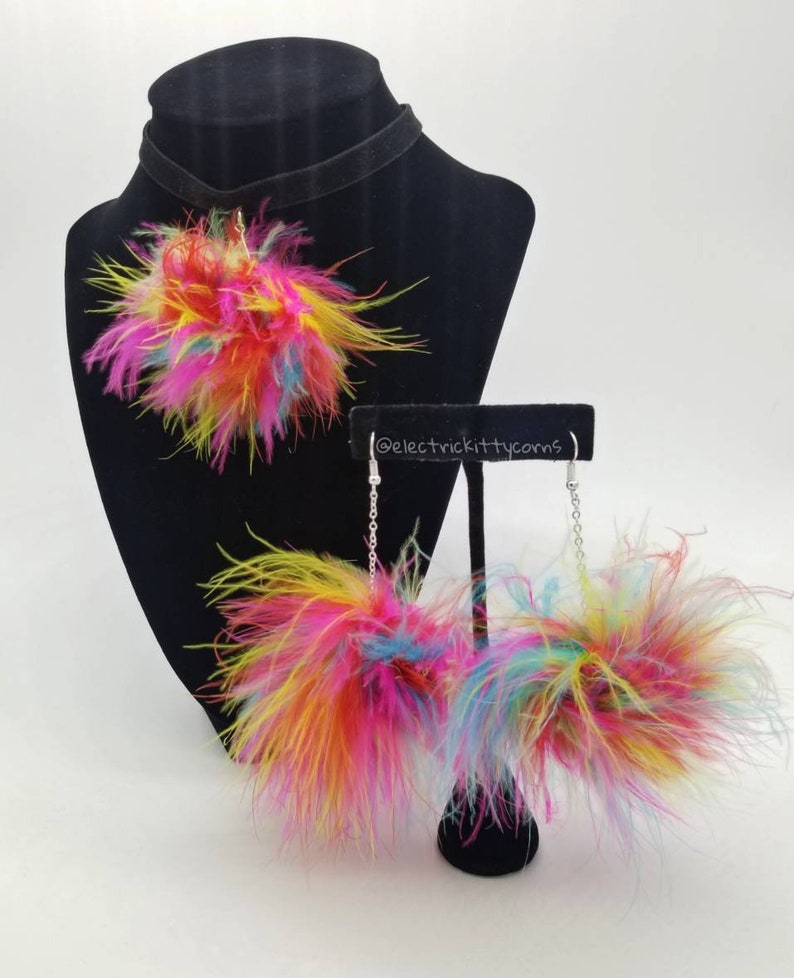 May include: A colorful feather choker necklace and matching earrings. The necklace and earrings feature a pom-pom style with multi-colored feathers.