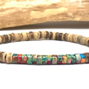 May include: A bracelet made of wooden and colourful stone beads. The bracelet has a circular design with a central section of vibrant, multi-coloured square beads. The wood beads are light brown with darker brown accents.