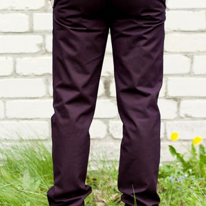 May include: A pair of dark purple pants with a back pocket and a button closure. The pants are made of a soft, comfortable fabric and have a relaxed fit.