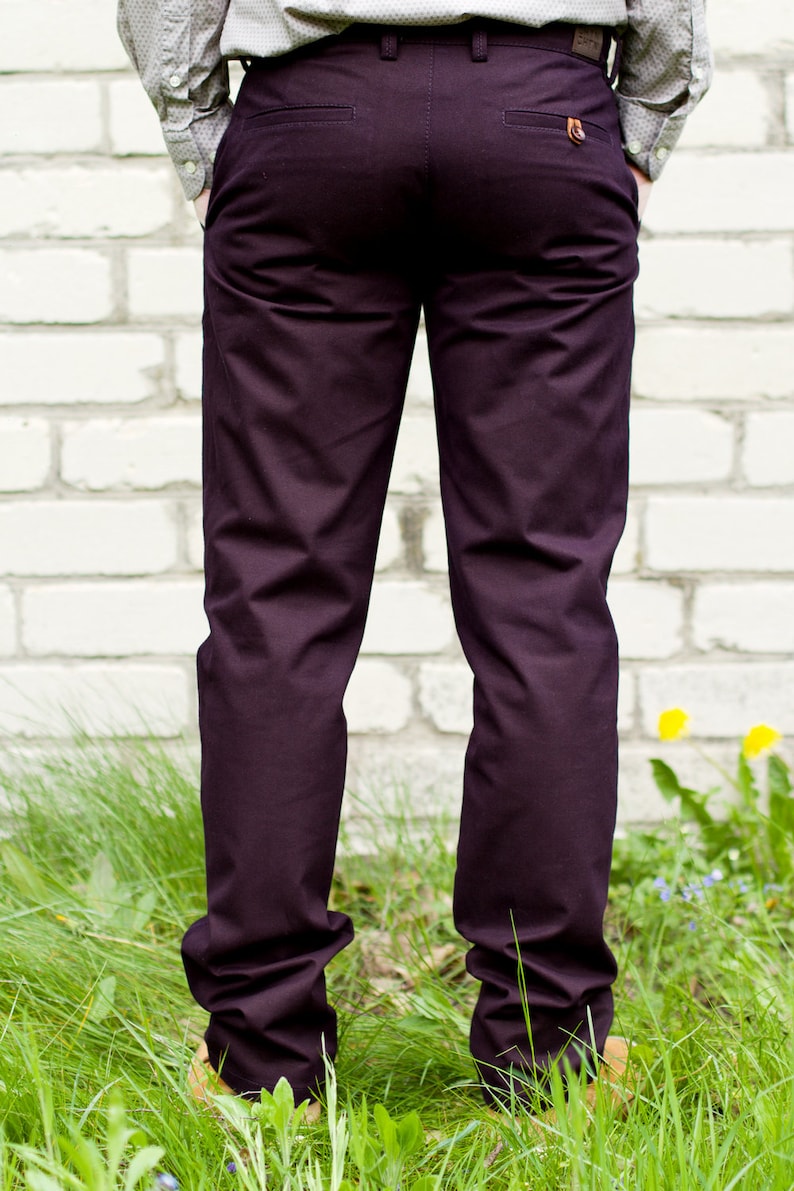 May include: A pair of dark purple pants with a back pocket and a button closure. The pants are made of a soft, comfortable fabric and have a relaxed fit.