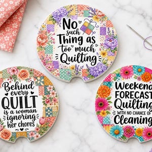 May include: Three round ceramic car coasters featuring colorful floral and patchwork quilt patterns. The top coaster reads No such thing as too much Quilting. The bottom left reads Behind every QUILT is a woman ignoring her chores. The bottom right reads Weekend Forecast Quilting with no chance of Cleaning.