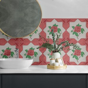 Puede incluir: Un tocador de baño con un lavabo blanco y un espejo redondo. El salpicadero está alicatado con azulejos blancos y rojos con un patrón floral con rosas rosas y hojas verdes.