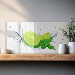 May include: Rectangular wall clock featuring a vibrant image of a lime slice, a lime wedge, and fresh mint leaves with water splashes. The clock has white hands and a minimalist design, perfect for a kitchen or dining area. The clock is approximately 24 inches wide.