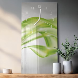 Peut inclure: Une horloge murale rectangulaire avec un motif abstrait vert. Le cadran de l'horloge comporte des chiffres et des aiguilles blancs. Le fond est un dégradé de blanc et de gris. L'horloge est affichée sur une surface en bois.