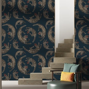 Peut inclure: Un papier peint bleu sarcelle avec un motif répété de tigres stylisés dorés et blancs. Les tigres se font face et ont des accents rouges sur leurs visages. Le papier peint est présenté dans une pièce avec un escalier et une chaise.