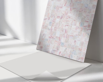 May include: A sheet of peel and stick tile backsplash with a pink and white marble mosaic pattern. The sheet is lying on a white surface.