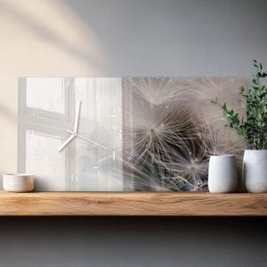 May include: Rectangular wall clock featuring a dandelion seed head image. The clock face has a white window pane design with white clock hands and numerals. The clock is displayed on a wooden shelf with white vases and greenery.