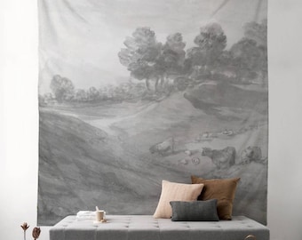 May include: A gray and white tapestry with a watercolor painting of a landscape with trees and hills. The tapestry is hanging on a wall above a gray couch with pillows.
