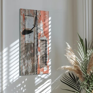 May include: A rectangular wall clock with a distressed wood design. The clock face features black numerals and hands against a backdrop of weathered wood in shades of brown, white, and coral. The clock is mounted on a white wall.