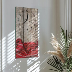 May include: A rectangular wall clock with a rustic wooden effect background and black clock hands. The clock face has black numerals. A red and white plaid pattern is at the bottom. The clock is mounted on a white wall.
