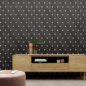 May include: A wooden media console with two drawers and an open shelf. The console is in front of a black wall with a white geometric pattern. There are books and decorative items on the shelf.