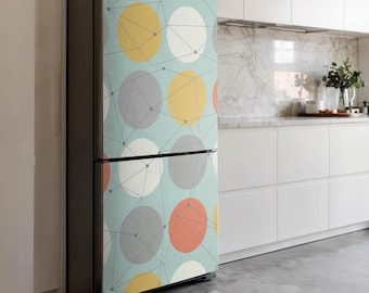 May include: A fridge with a vibrant geometric pattern. The design showcases large circles in yellow, grey, coral, and white, linked by thin grey lines, on a light blue backdrop. The fridge has a dark grey frame, presenting a modern aesthetic.