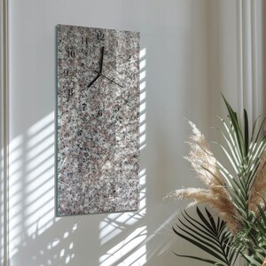 May include: A rectangular wall clock with a granite-like pattern. The clock face features black numerals and hands against a speckled background of gray, white, and brown. The clock is mounted on a white wall.