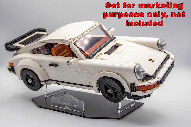 May include: White Lego Porsche 911 Turbo model on a black display stand with a clear acrylic plaque that reads "Porsche 911 Turbo".