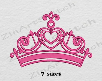 May include: Pink embroidered crown with a heart design. The crown has a curved bottom and a pointed top.