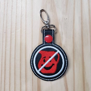 May include: Black leather keychain with a red and white embroidered circle. The circle has a red pitcher with a diagonal line through it. The keychain has a silver metal clasp.