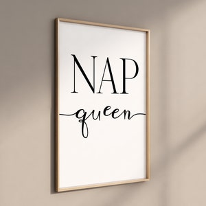 Może przedstawiać: Biały wydruk w ramie z czarnym tekstem, który brzmi "NAP queen" w ozdobnym kroju pisma.