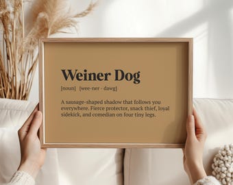 May include: A framed print featuring the words "Weiner Dog" and its phonetic pronunciation. The definition describes a dachshund as a sausage-shaped shadow, fierce protector, snack thief, loyal sidekick, and comedian.