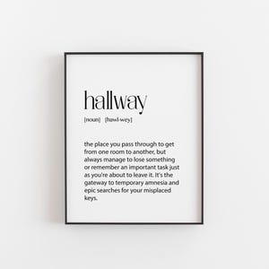 Könnte beinhalten: Schwarz gerahmter Druck mit dem Wort "hallway" in einer modernen Schriftart. Die Definition beschreibt den Flur als einen Ort, an dem Dinge verloren gehen und Aufgaben in letzter Minute erinnert werden.