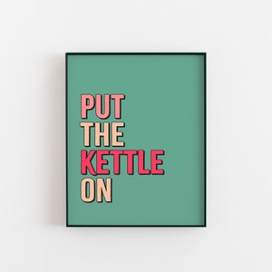 以下が含まれることがあります： ピンク、オレンジ、赤で「PUT THE KETTLE ON」と書かれた、緑がかった青色の額装されたプリントです。