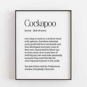 May include: A framed wall art print featuring a dictionary-style definition of the word Cockapoo. The text includes the phonetic pronunciation, the noun classification, and a humorous description of the dog breed's personality and traits.
