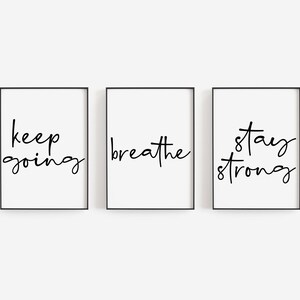 Könnte beinhalten: Drei schwarze gerahmte Drucke mit weißen Hintergründen und schwarzem handgeschriebenen Text. Die Drucke lauten "keep going", "breathe" und "stay strong".