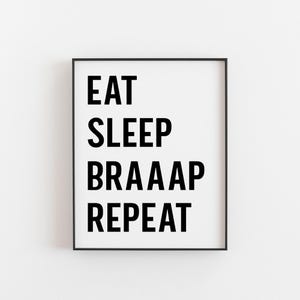 May include: Black and white framed print with the text "EAT SLEEP BRAAAP REPEAT" on a white background.