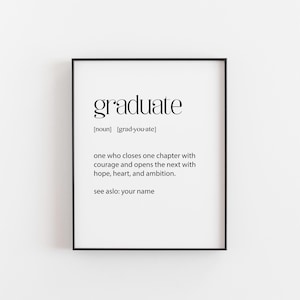 May include: A black framed print featuring the word "graduate" in elegant typography. The definition is provided, including pronunciation and a motivational message about closing one chapter and starting the next. The frame is black.