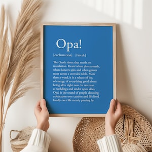 May include: A framed print featuring the word "Opa!" in white against a blue backdrop. The text explains the Greek exclamation, describing it as a joyful expression of celebration.