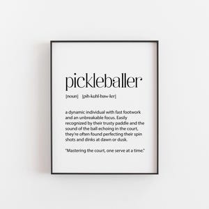 May include: Black and white printable wall art with a definition of the word "pickleballer". The definition describes a pickleballer as a dynamic individual with fast footwork and an unbreakable focus. The definition also mentions that pickleballers are easily recognised by their trusty paddle and the sound of the ball echoing in the court. The definition concludes with the phrase "Mastering the court, one serve at a time."
