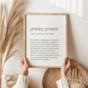 Könnte beinhalten: Ein gerahmter Druck mit weißem Hintergrund und schwarzem Text, der "grumpy grandad [noun] [grum-pee - gran-dad] the lovable curmudgeon of the family, known for his wisecracks and playful grumbles. He may complain about the younger generation, but beneath that gruff exterior is a heart of gold, always ready with a hug and a life lesson. Whether he's watching his favourite TV show or sharing a cheeky joke, he's the grumpy yet endearing presence that brings the family together." lautet.