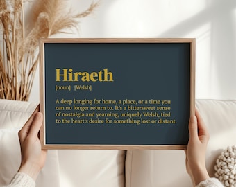 Op de afbeelding: Een ingelijst afdruk met een donkerblauwe achtergrond en gouden tekst. De tekst luidt "Hiraeth [zelfstandig naamwoord] [Welsh] Een diep verlangen naar huis, een plek of een tijd waar je niet meer naar terug kunt. Het is een zoet-zure gevoel van nostalgie en verlangen, uniek Welsh, verbonden met het verlangen van het hart naar iets dat verloren is of ver weg is."