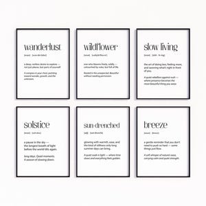 Könnte beinhalten: Sechs gerahmte Kunstdrucke mit schwarzen Rahmen und weißen Hintergründen. Jeder Druck zeigt ein Wort in einer fetten, serifenlosen Schriftart, wie "Wanderlust" und "Slow Living", zusammen mit einer Definition. Die Drucke sind in zwei Reihen zu je drei angeordnet.