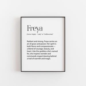 Puede incluir: Un p&oacute;ster enmarcado con el nombre "Freya" en negrita y en negro en la parte superior. El texto de abajo describe los atributos de Freya, incluyendo gracia, poder, coraje y belleza. El marco es negro y el fondo es blanco.