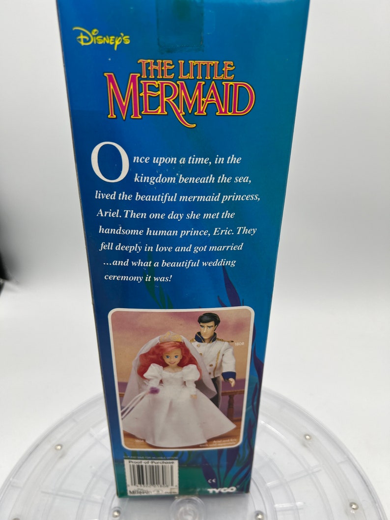 Pode incluir: Uma caixa para um conjunto de bonecas Disney's The Little Mermaid. A caixa apresenta um fundo azul com o t&iacute;tulo "Disney's The Little Mermaid" em texto branco. A caixa tamb&eacute;m apresenta uma imagem de Ariel e Eric em seus trajes de casamento. O texto na caixa diz: "Era uma vez, no reino debaixo do mar, vivia a bela princesa sereia, Ariel. Um dia ela conheceu o belo pr&iacute;ncipe humano, Eric. Eles se apaixonaram profundamente e se casaram... e que bela cerim&ocirc;nia de casamento foi!"