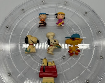 Könnte beinhalten: Ein Set mit sechs Vintage-Figuren der Peanuts-Charaktere. Die Figuren sind aus Kunststoff und zeigen Charlie Brown, Snoopy, Lucy, Linus, Woodstock und Sally. Die Figuren sind alle in gutem Zustand und haben keine Absplitterungen oder Risse.