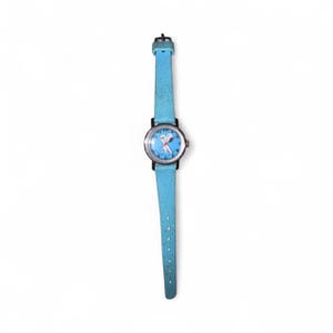May include: A vintage wristwatch with a light blue leather strap and a round face. The watch face features a cartoon character on a blue background with white numbers and hands. The watch has a silver-coloured metal casing.