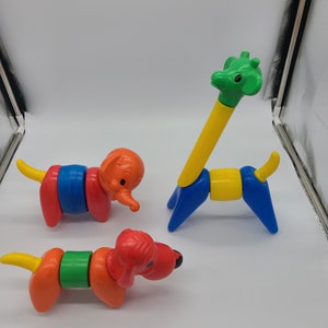 May include: Three colorful, segmented animal toys: an orange elephant, a red dog, and a yellow and blue giraffe. Each toy is made of plastic and has a segmented body, allowing for movement. The toys are designed for children.
