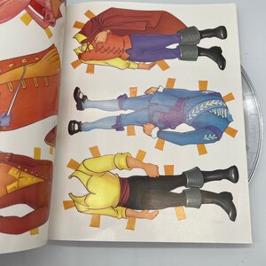 Puede incluir: Un libro de mu&ntilde;ecas de papel con cuatro mu&ntilde;ecas de papel diferentes. Las mu&ntilde;ecas est&aacute;n vestidas con diferentes atuendos, incluyendo un atuendo rojo y amarillo, un atuendo azul y amarillo y un atuendo amarillo y marr&oacute;n. Las mu&ntilde;ecas est&aacute;n todas de pie sobre un fondo blanco.
