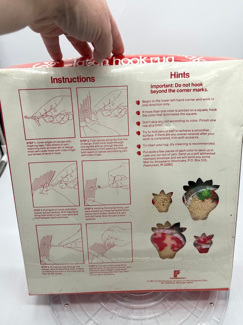 Puede incluir: Instrucciones para un kit de alfombra de gancho de cierre con un dise&ntilde;o de fresa. Las instrucciones muestran c&oacute;mo usar la herramienta de gancho de cierre para crear la alfombra. El kit incluye un lienzo preimpreso, hilo y una herramienta de gancho de cierre.