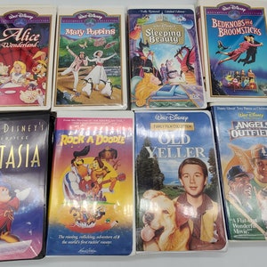 Op de afbeelding: Een verzameling Walt Disney VHS-banden met animatieklassiekers als "Alice in Wonderland", "Mary Poppins" en "Sleeping Beauty". Andere titels zijn "Fantasia", "Rock-a-Doodle" en "Angels in the Outfield". De banden hebben kleurrijke hoezen.