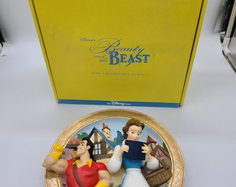 Könnte beinhalten: Eine gelbe Box mit dem Text "Disney's Beauty and the Beast One Collectible Plate" und einem 3D-Reliefteller mit Belle und dem Biest aus dem Disney-Film Die Schöne und das Biest.