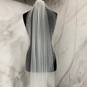 Wedding veil with pearls. A scattering of pearls along the edge of the veil. Veil one layer.