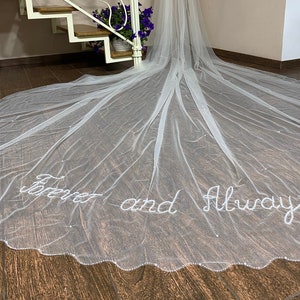 Velo de novia personalizado con pequeñas perlas. Borde del velo ondulado. Letras y palabras con cuentas en el velo. Velo con tus iniciales y monograma personalizados.