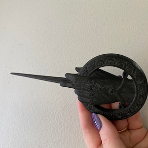 Hand of the king or queen in black color and no pin by default.